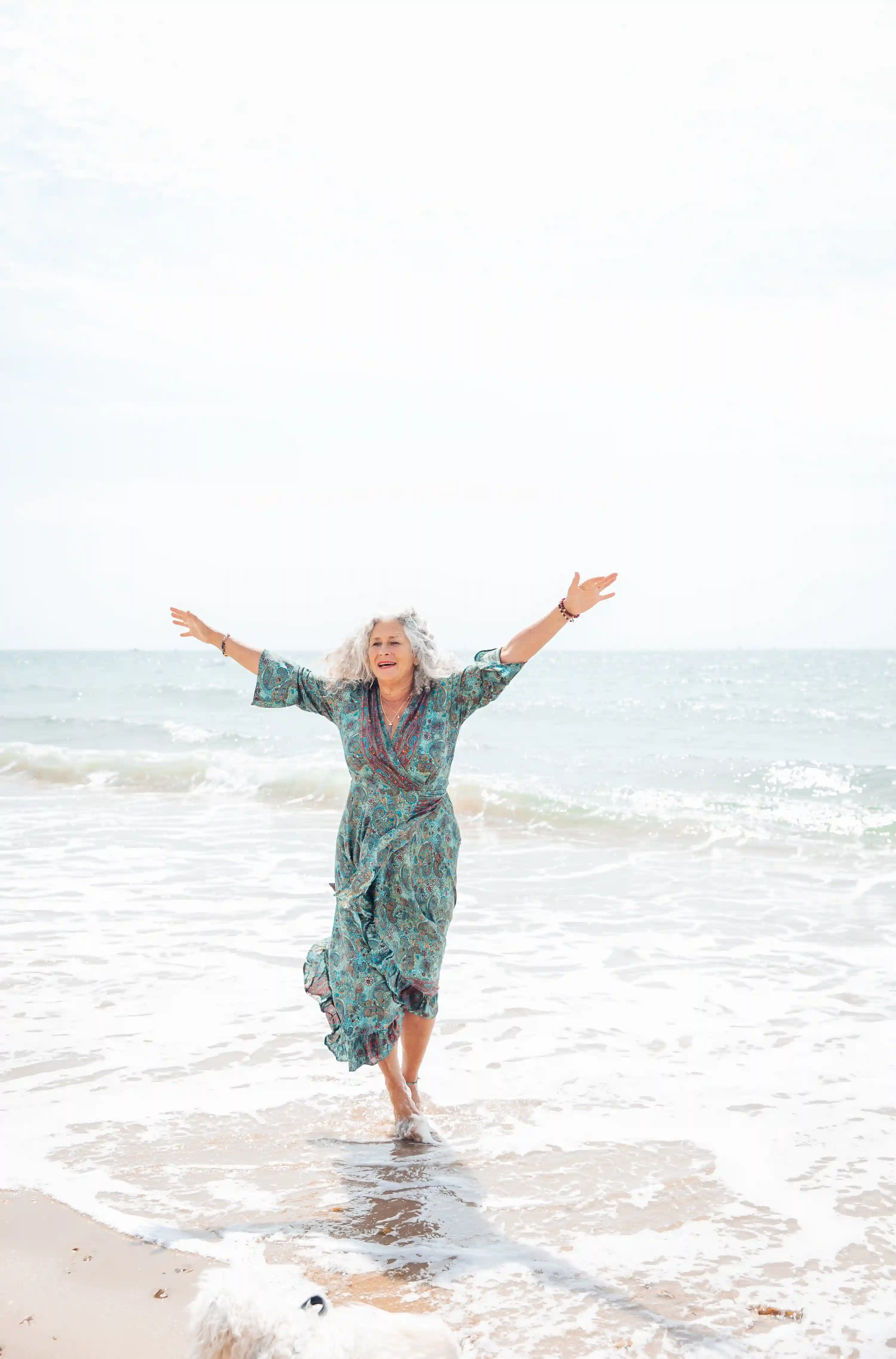 Image of Jyoti sat at the beach embracing her freedom.