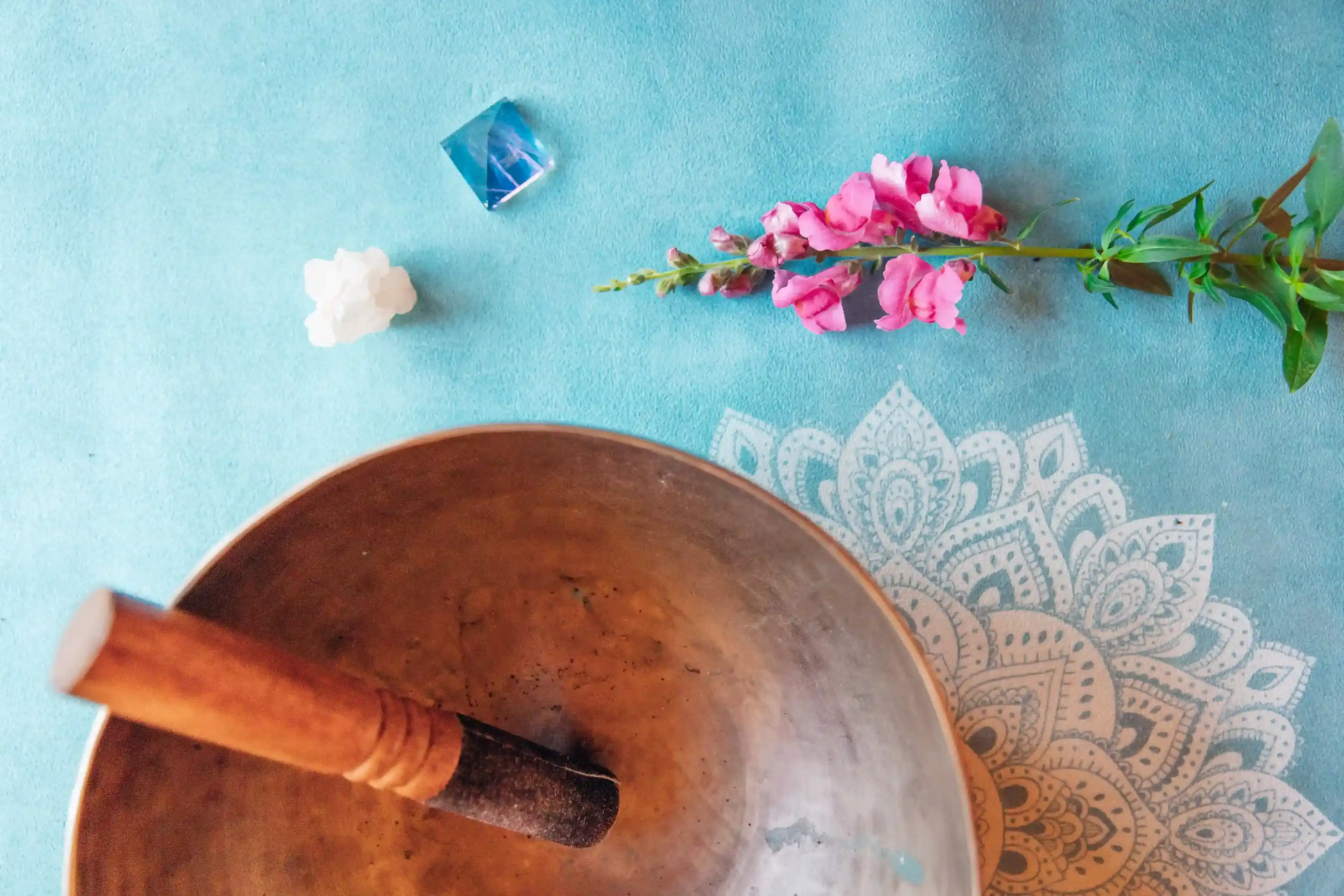 Singing bowl and items on a yoga mat.